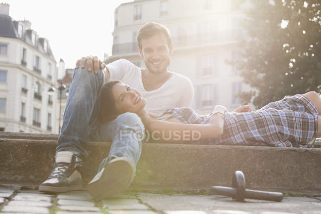 Woman lying on lap of a man at the ledge of a canal, Paris, Ile-de-France, France — Stock Photo