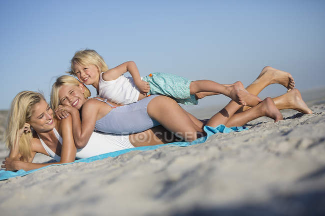 Junge Frau genießt mit Kindern am Sandstrand — Stockfoto