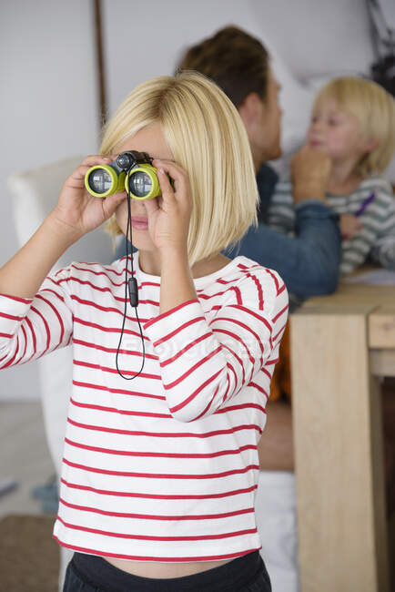 Chica mirando a través de binoculares - foto de stock