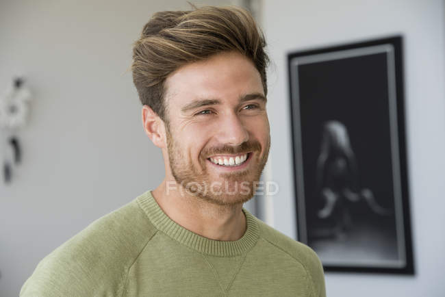 Крупним планом усміхнений молодий бородатий чоловік дивиться геть — стокове фото