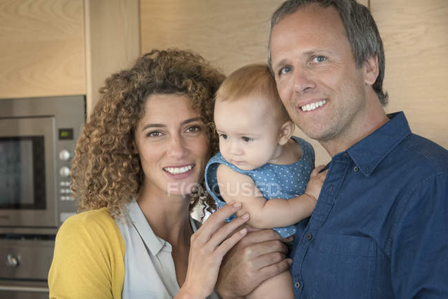 Portrait of happy couple with baby daughter — Stock Photo