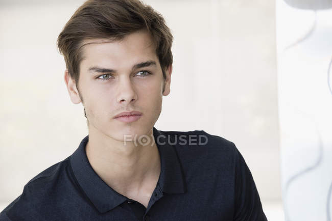 Portrait de beau jeune homme aux cheveux bruns détournant les yeux — Photo de stock