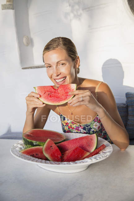 Porträt einer Frau, die ein Stück Wassermelone isst — Stockfoto