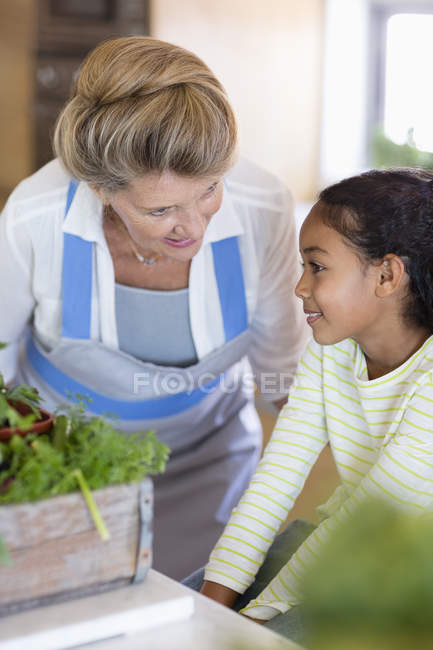Щаслива старша жінка з онукою на кухні — стокове фото