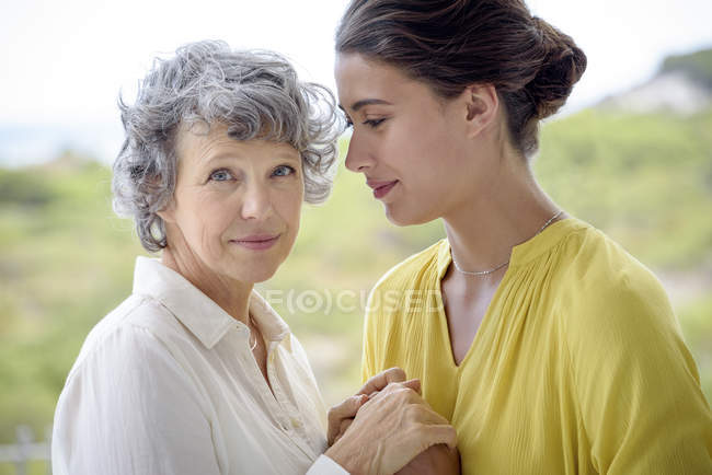 Portrait of loving mother and daughter holding hands outdoors — Stock Photo