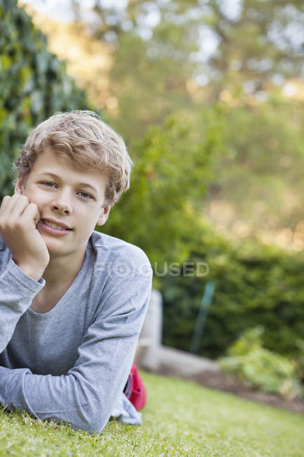Портрет хлопчика-підлітка, що лежить на траві — стокове фото