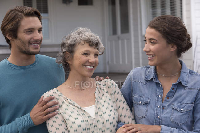 Glücklich reife Frau steht mit jungen Paar im Freien — Stockfoto