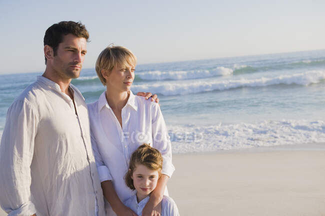 Famiglia in piedi sulla spiaggia — Foto stock