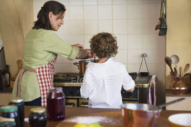 Avó e menino cozinhar comida juntos em casa — Fotografia de Stock