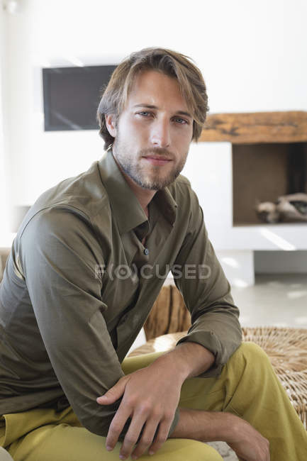 Retrato de homem bonito sentado na sala de estar — Fotografia de Stock
