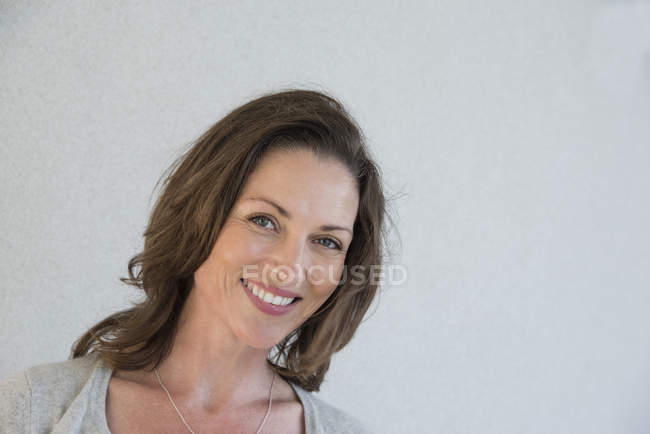Retrato de mulher madura feliz no fundo cinza — Fotografia de Stock