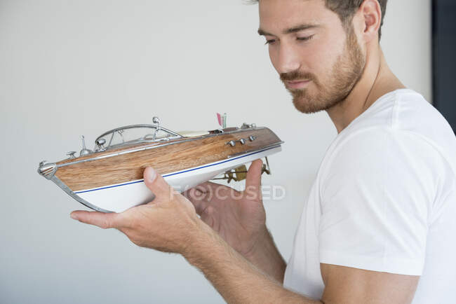 Young man holding a model boat — Stock Photo