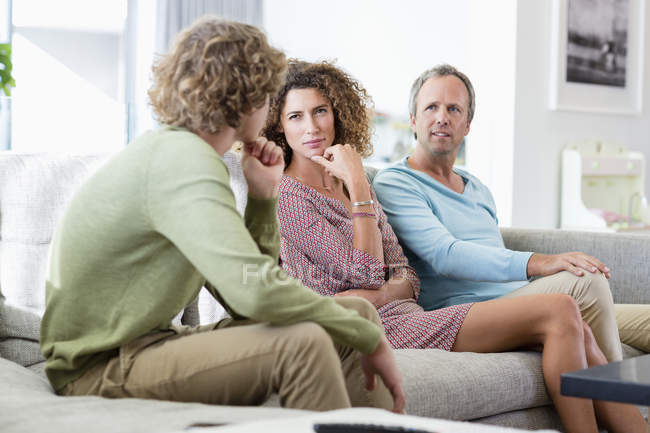 Família feliz conversando na sala de estar em casa — Fotografia de Stock