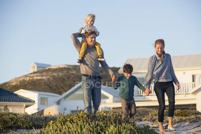 Happy family walking in front of house in countryside — Stock Photo