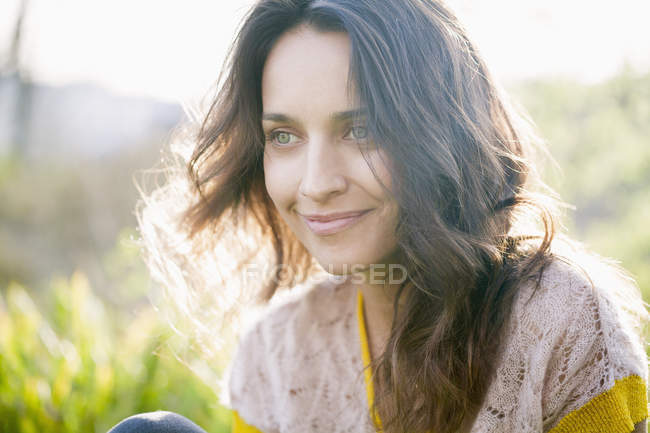 Smiling dreamy woman relaxing in nature — Stock Photo