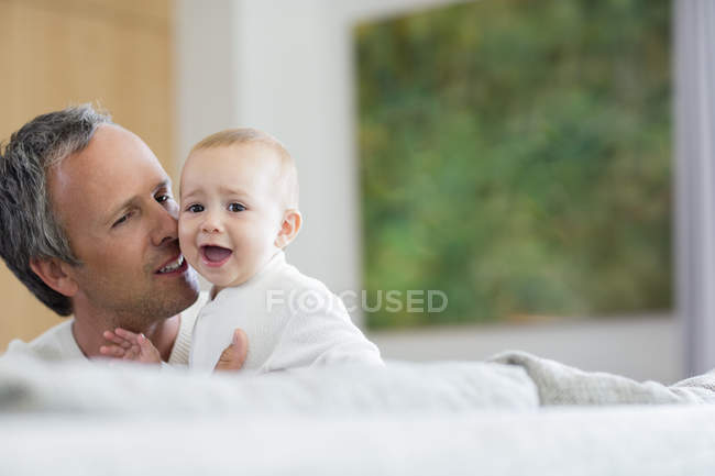 Feliz pai abraçando bonito bebê filha em casa — Fotografia de Stock