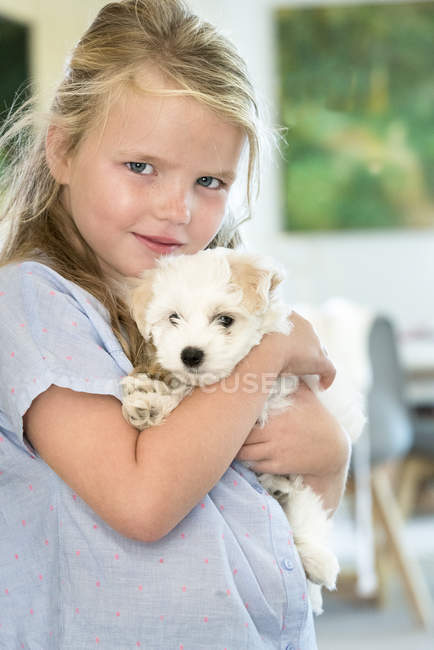 Retrato de linda niña sosteniendo cachorro - foto de stock