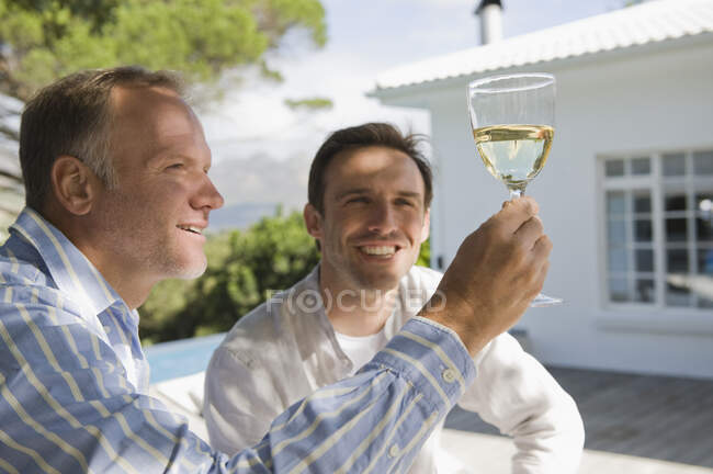 Dois amigos olhando para um copo de vinho — Fotografia de Stock