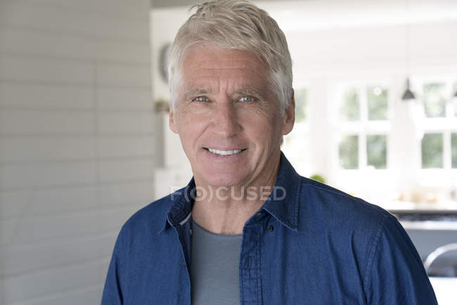 Портрет літнього чоловіка, який посміхається вдома — стокове фото