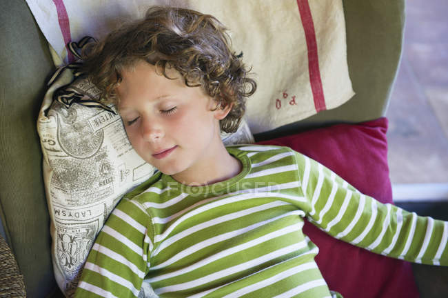 Cute little boy relaxing in armchair at home — Stock Photo