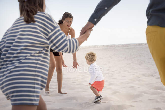 Felice giovane famiglia godendo sulla spiaggia — Foto stock