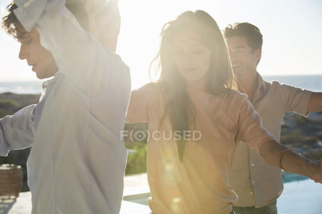 Groupe d'amis dansant au bord de la piscine — Photo de stock