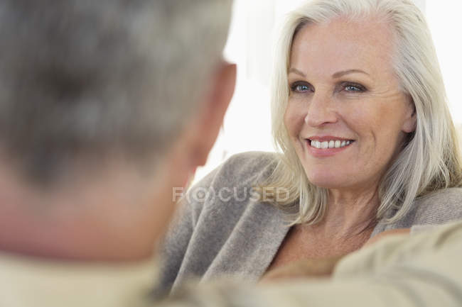 Primo piano di una donna anziana premurosa seduta con il marito sul divano a casa — Foto stock