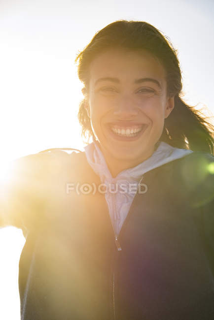 Портрет молодої щасливої жінки, яка посміхається яскравим сонячним світлом — стокове фото