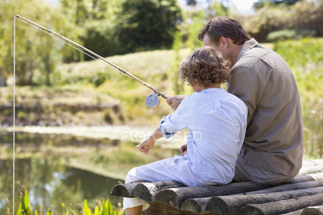 Отец и сын рыбачат в озере — стоковое фото