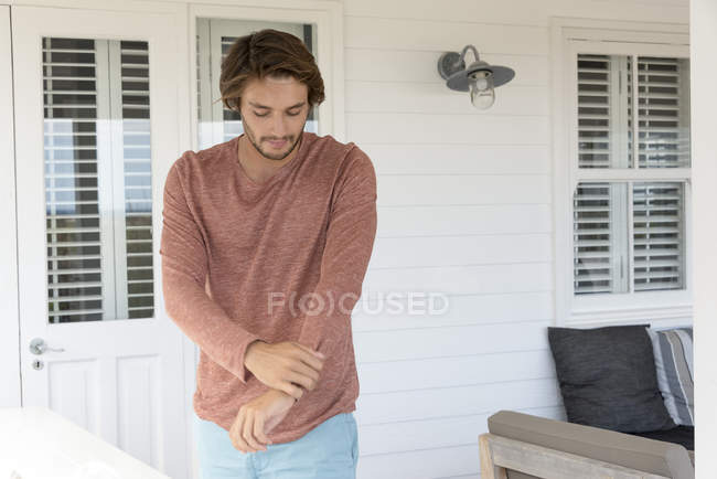 Молодой человек стоит на террасе и смотрит вниз — стоковое фото