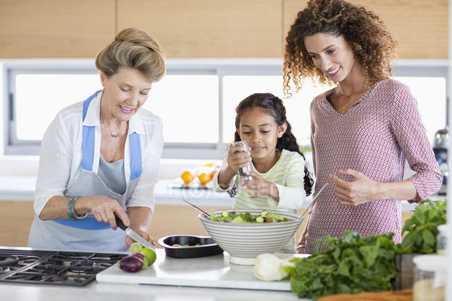Старші жінки з дочку і онука, приготування їжі на кухні — стокове фото