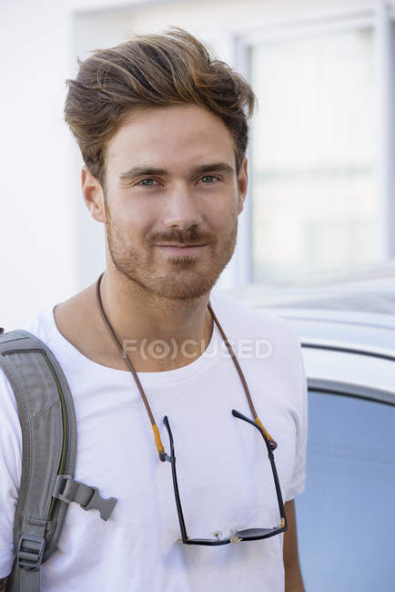 Retrato de jovem feliz em pé na frente do carro — Fotografia de Stock