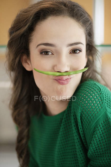 Portrait of woman making fun with a French bean — Stock Photo