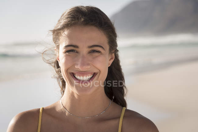 Портрет молодої усміхненої жінки на пляжі — стокове фото