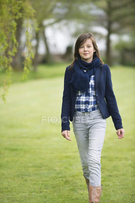 Девочка-подросток идет по зеленому полю — стоковое фото