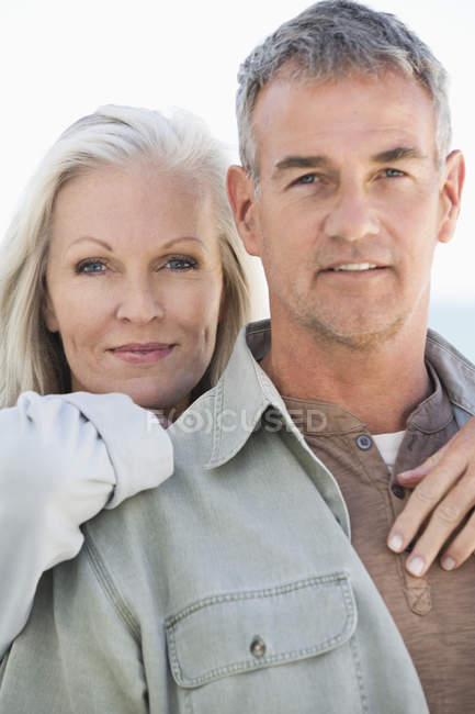Retrato de feliz casal descontraído em pé na praia — Fotografia de Stock