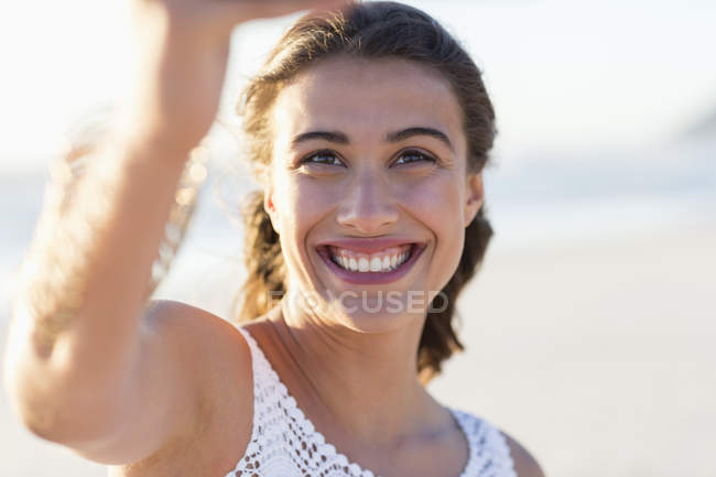 Щаслива молода жінка бере селфі на пляжі — стокове фото