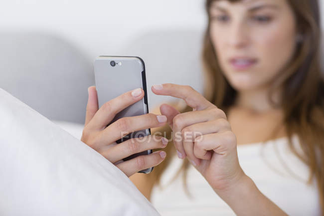 Крупним планом молода жінка обміну повідомленнями з мобільним телефоном — стокове фото