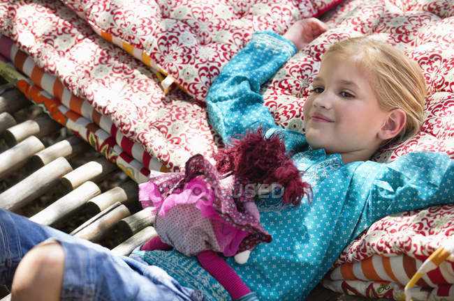 Portrait de petite fille couchée dans un hamac avec jouet — Photo de stock