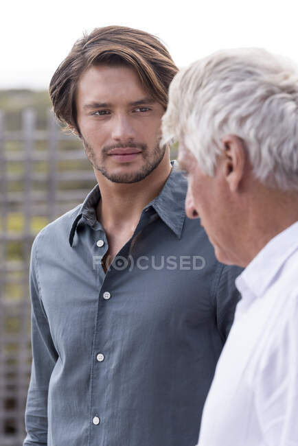 Отец и сын разговаривают снаружи — стоковое фото