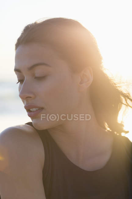 Jeune femme sensuelle posant sur la plage au soleil — Photo de stock
