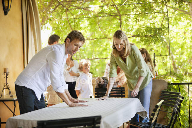 Casal preparando mesa de jantar para o tempo de refeição — Fotografia de Stock