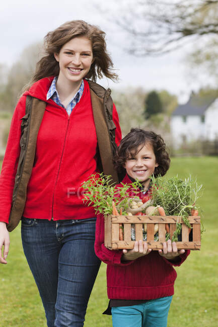 Madre e figlio con una cassa di verdure fatte in casa — Foto stock
