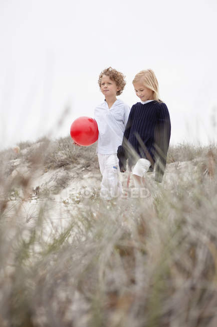 Menino e menina andando juntos na costa — Fotografia de Stock