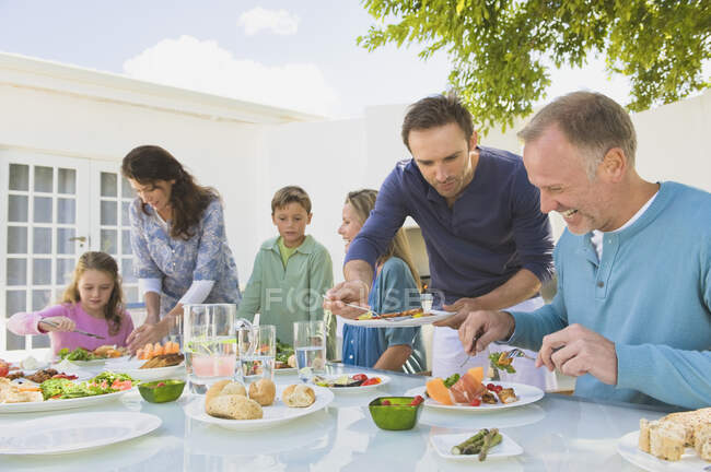 Familia desayunando en la mesa del comedor - foto de stock