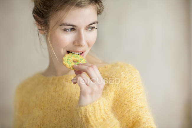 Close-up de jovem loira comendo biscoito — Fotografia de Stock