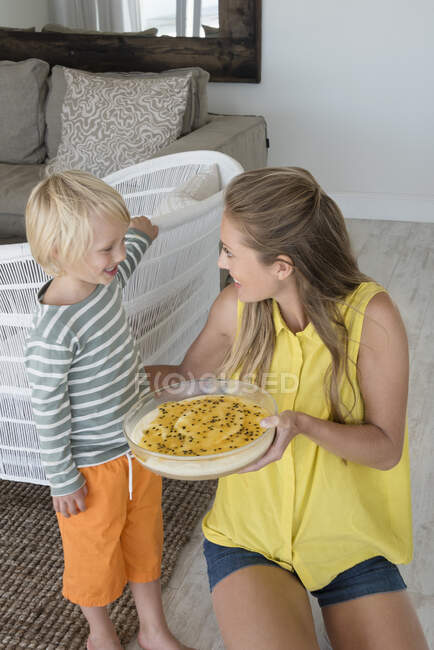 Mãe e filho felizes com comida na sala de estar — Fotografia de Stock