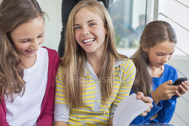Alunos do sexo feminino sentados e rindo na escola — Fotografia de Stock