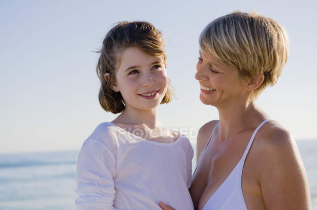 Mulher com filha desfrutando de férias na praia — Fotografia de Stock