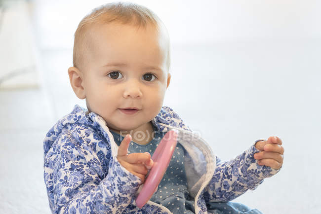 Close-up de bebê menina jogando segurando brinquedo — Fotografia de Stock